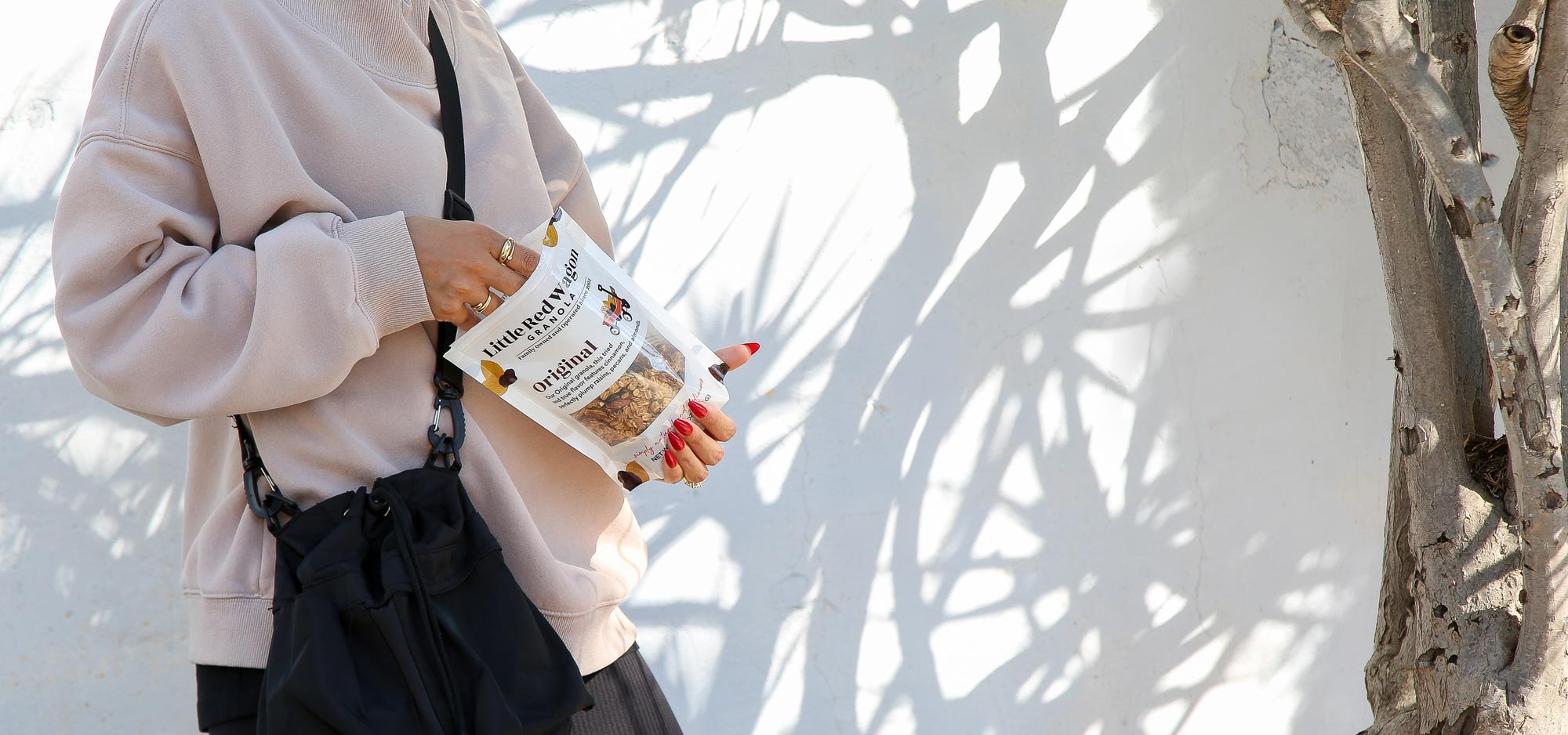 woman eating Little Red Wagon Granola from the bag, buy granola online