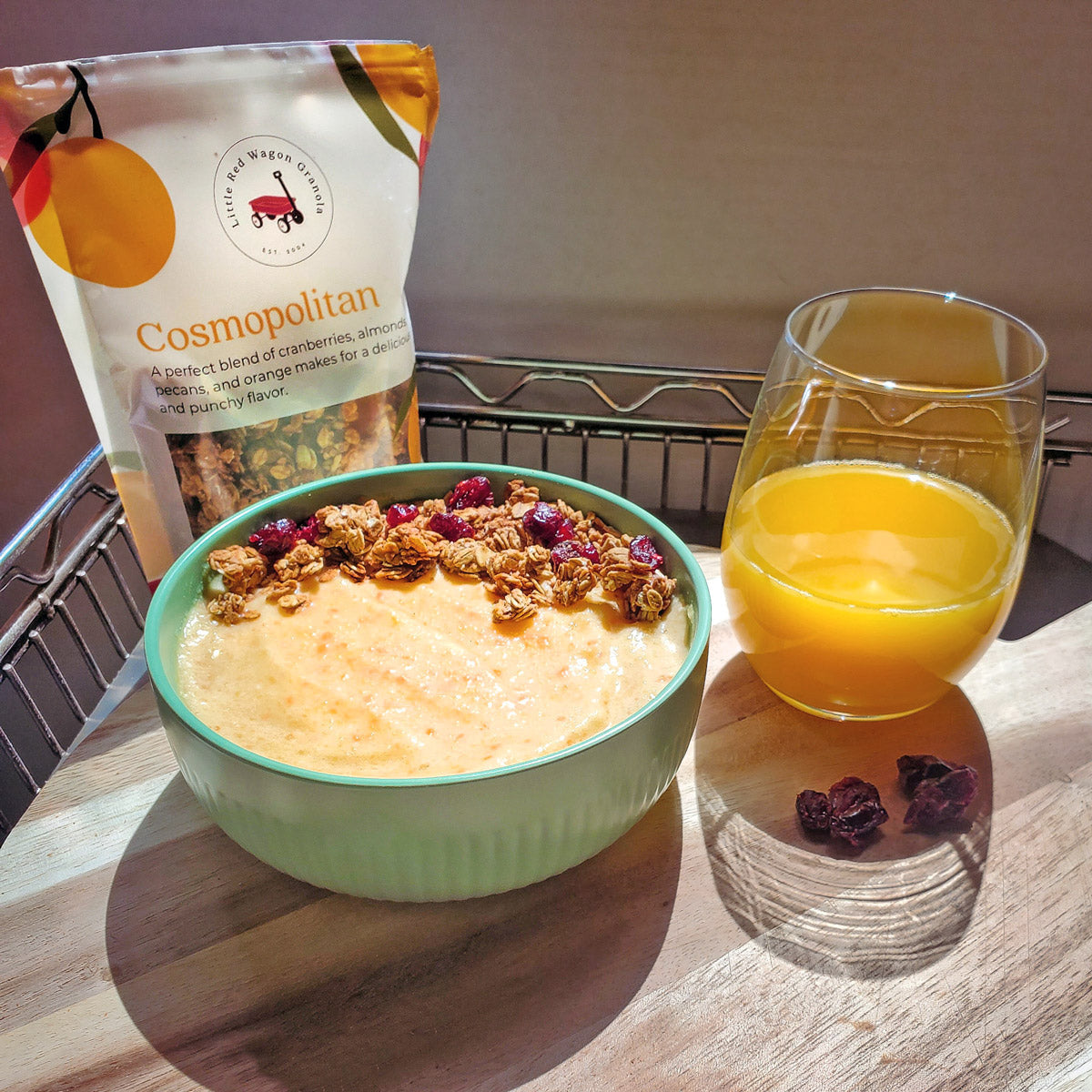 granola smoothie bowl in the sunshine next to handmade granola and orange juice