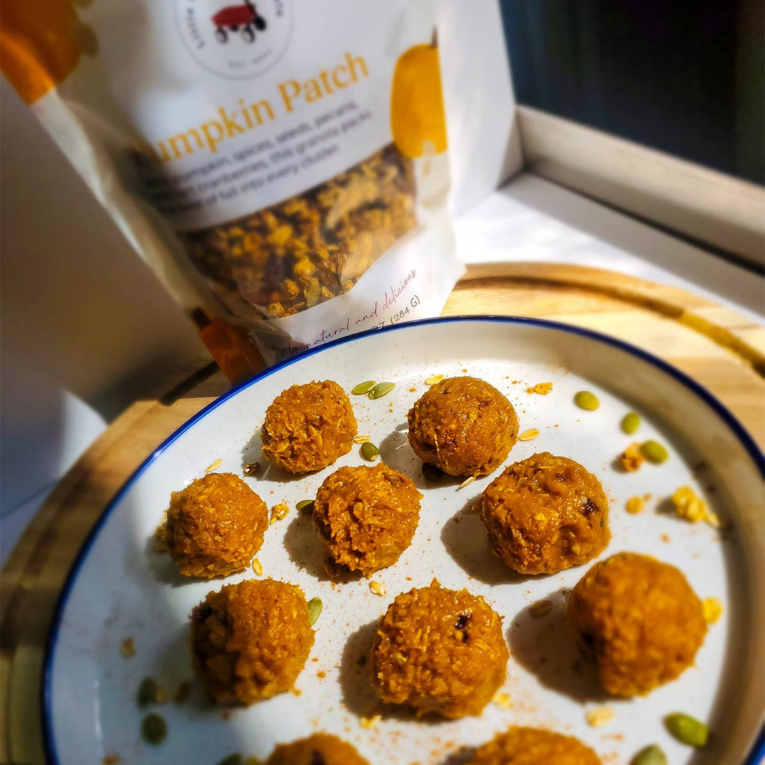 Pumpkin pie balls sitting next to a package of Little Red Wagon Pumpkin Patch Granola
