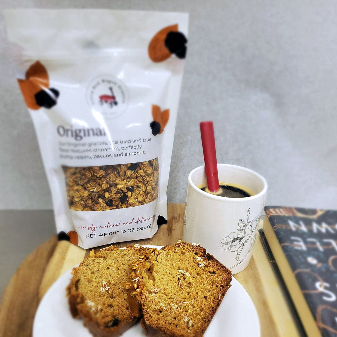 Granola cake beside a mug of hot coffee and a package of Little Red Wagon Original Flavor granola