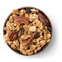 Wooden bowl filled with granola, nuts, and raisins on a white background