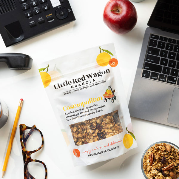Little Red Wagon Granola package on a desk with laptop, phone, and apple