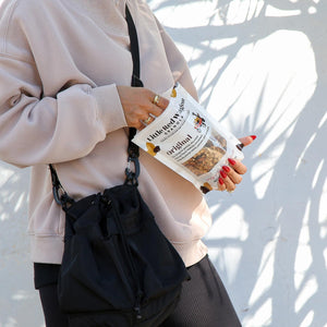 Person holding a bag of Original Granola against a white background
