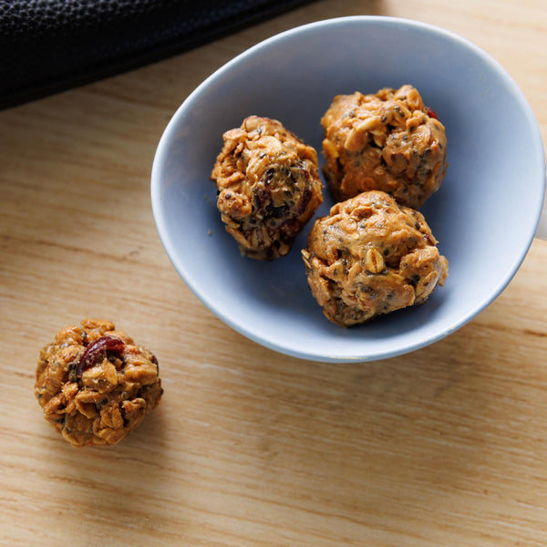 Three oatmeal raisin cookies on a blue plate on a wooden surface