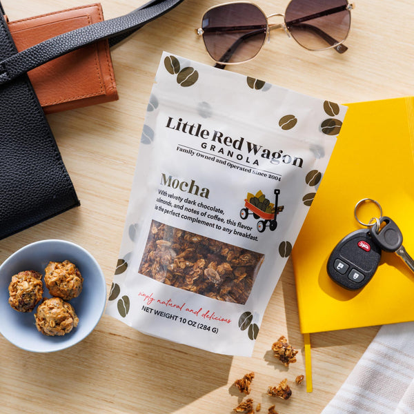 Little Red Wagon Granola package on a table with snacks, sunglasses, and keys.