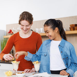 Two people preparing a dessert in a kitchen
