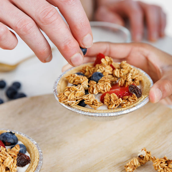 Small tarts with granola and berries on a wooden surface